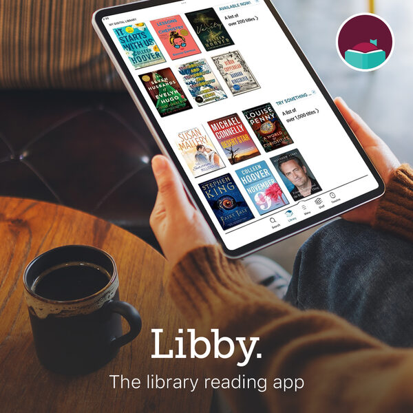 Jemand sitzt mit einer Tasse Kaffee am Tisch und liest benutzt Libby auf einem Tablet (Wird bei Klick vergrößert)