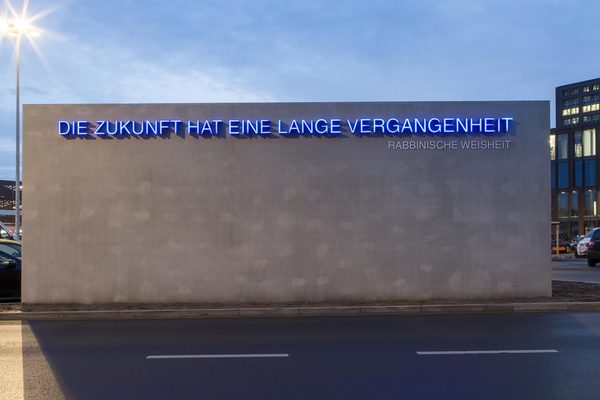 Blauleuchtender Schriftzug "Die Zukunft hat eine lange Vergangenheit" als Teil der Gedenkstätte Schillstraße (Wird bei Klick vergrößert)