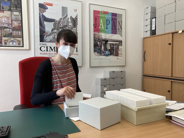 FSJ-lerin Anna Holz sortiert und verpackt Glasplattennegative in Boxen, damit sie in das Archiv zur Lagerung transportiert werden können.