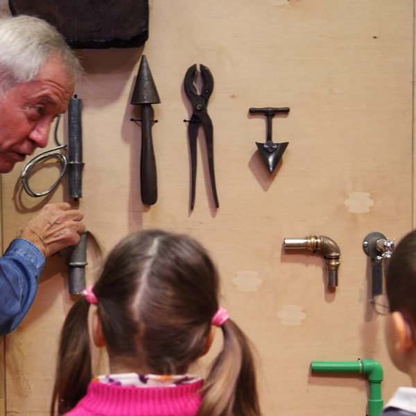 Foto Klempnermeister Voges erklärt Kindern sein Handwerk (Wird bei Klick vergrößert)