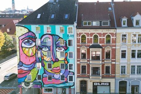 Ein Kunstwerk an einer Hausfassade an der Mühlenpfordstraße. Entstanden beim Hola Utopia! 2024.
