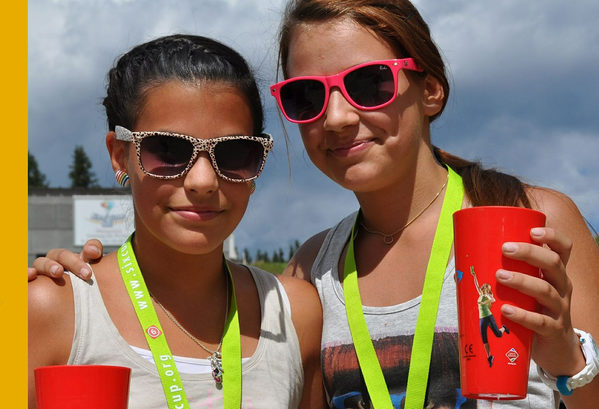 zwei Mädchen mit Sonnenbrille und Getränk in der Hand