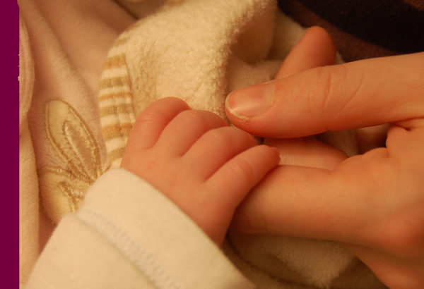 Babyhand umklammert mütterlichen Finger