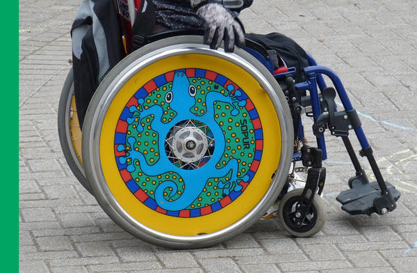 Rollstuhl mit buntem Rad