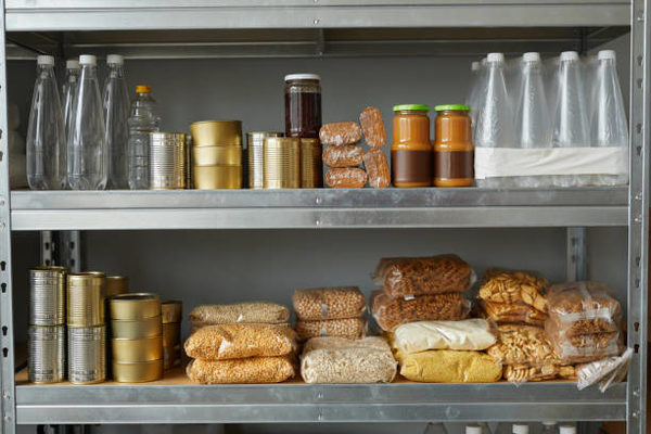 Background image of shelves stacked with food donations at help center for refugees and people in need, copy space (Wird bei Klick vergrößert)