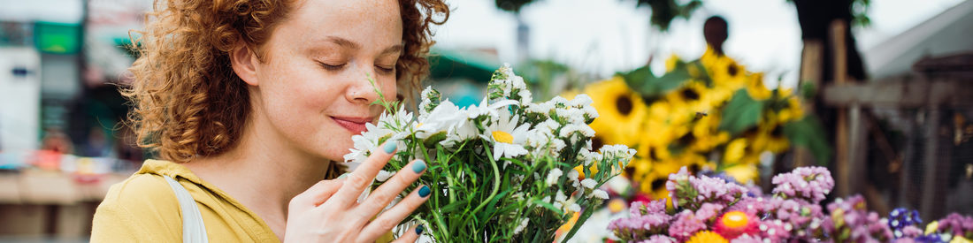 Frau riecht an Blumenstrauß