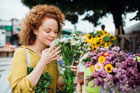 Frau riecht an Blumenstrauß