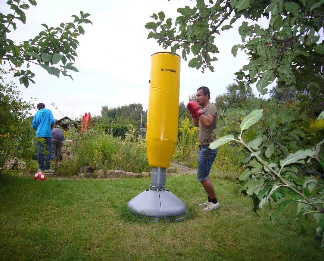 Ein Mann boxt im Garten mit einem Boxständer
