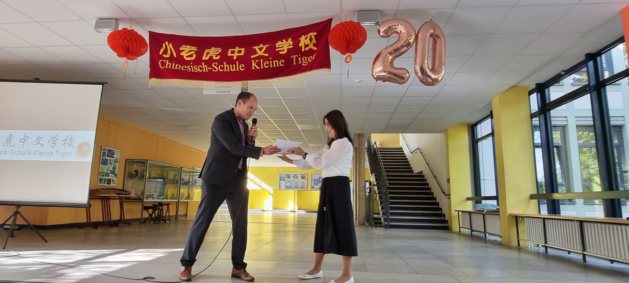 Stadtrat Dr. Tobias Pollmann überreicht Sashuang Li, Schulleiterin Kleine Tiger, Glückwünsche aus Braunschweigs Partnerstadt Zhuhai. (Wird bei Klick vergrößert)