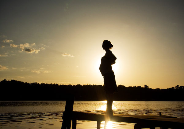 Silhouette einer schwangeren Frau am See vor dem Sonnenuntergang (Wird bei Klick vergrößert)