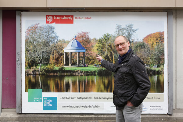 Fotowettbewerb „#braunschweigistschön“ der Citymarketingkampagne „Ist schön. Wird schön“: Bernhard Riske vor seinem Gewinnermotiv „Ein Ort zum Entspannen – das Kennelgebiet“ auf einer 3,5 m mal 2,5 m großen Plakatwand. (Wird bei Klick vergrößert)