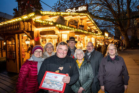 Der Gewinnerstand „Ross-Hütte“ von Stefan Franz (ganz vorne) ist in diesem Jahr bereits zum 40sten Mal Teil des Braunschweiger Weihnachtsmarktes. Es freuen sich die Jurymitglieder (v. l. n. r.) Dompredigerin Cornelia Götz (Braunschweiger Dom), Ingeborg Obi-Preuß (Braunschweiger Zeitung), Thomas Bronswyk (Schaustellerverband Braunschweig), Ulrike Neumann (Braunschweig Stadtmarketing GmbH), Karsten Ziaja (Arbeitsausschuss Tourismus Braunschweig e. V.) und Bezirksbürgermeisterin Jutta Plinke. Es fehlt: Jurymitglied Astrid Striese (Arbeitsausschuss Innenstadt Braunschweig e. V.).