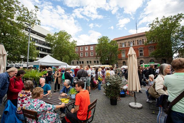 Regionale Zutaten für das Abendessen kaufen oder den Abend mit kühlen Drinks und leckeren Snacks in der Innenstadt verbringen: Zurückgelehnt in den Liegestühlen oder in Gruppen an den Tischen genießen die Besucherinnen und Besucher das kulinarische und musikalische Marktangebot. (Wird bei Klick vergrößert)