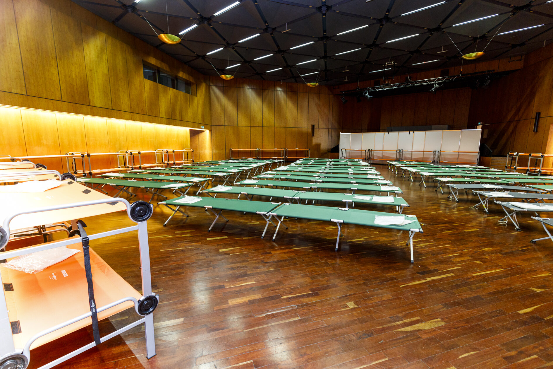 Das Bild zeigt Behelfsbetten in der Stadthalle. (Wird bei Klick vergrößert)