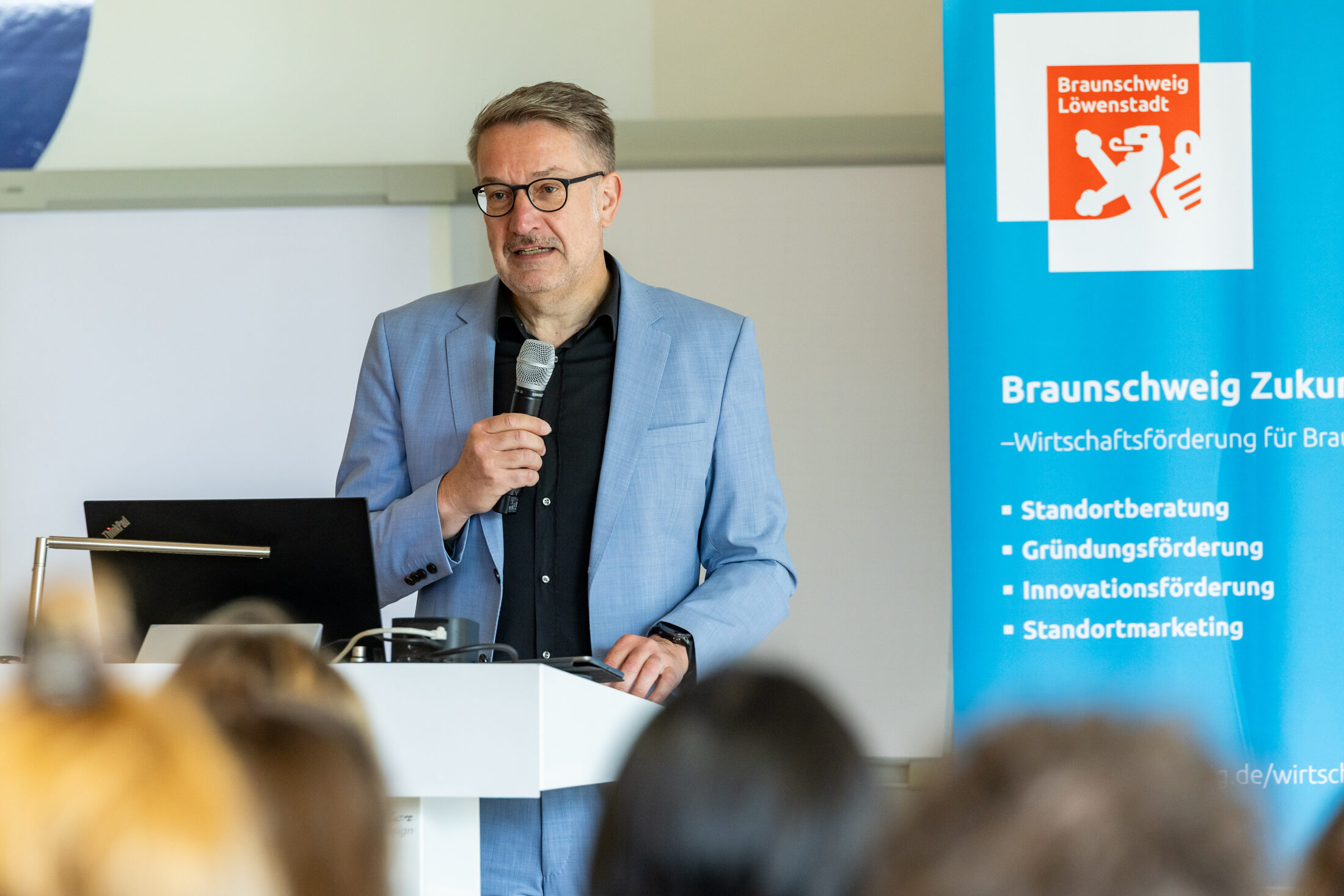 Ein Mann spricht ins Mikrofon (Wird bei Klick vergrößert)