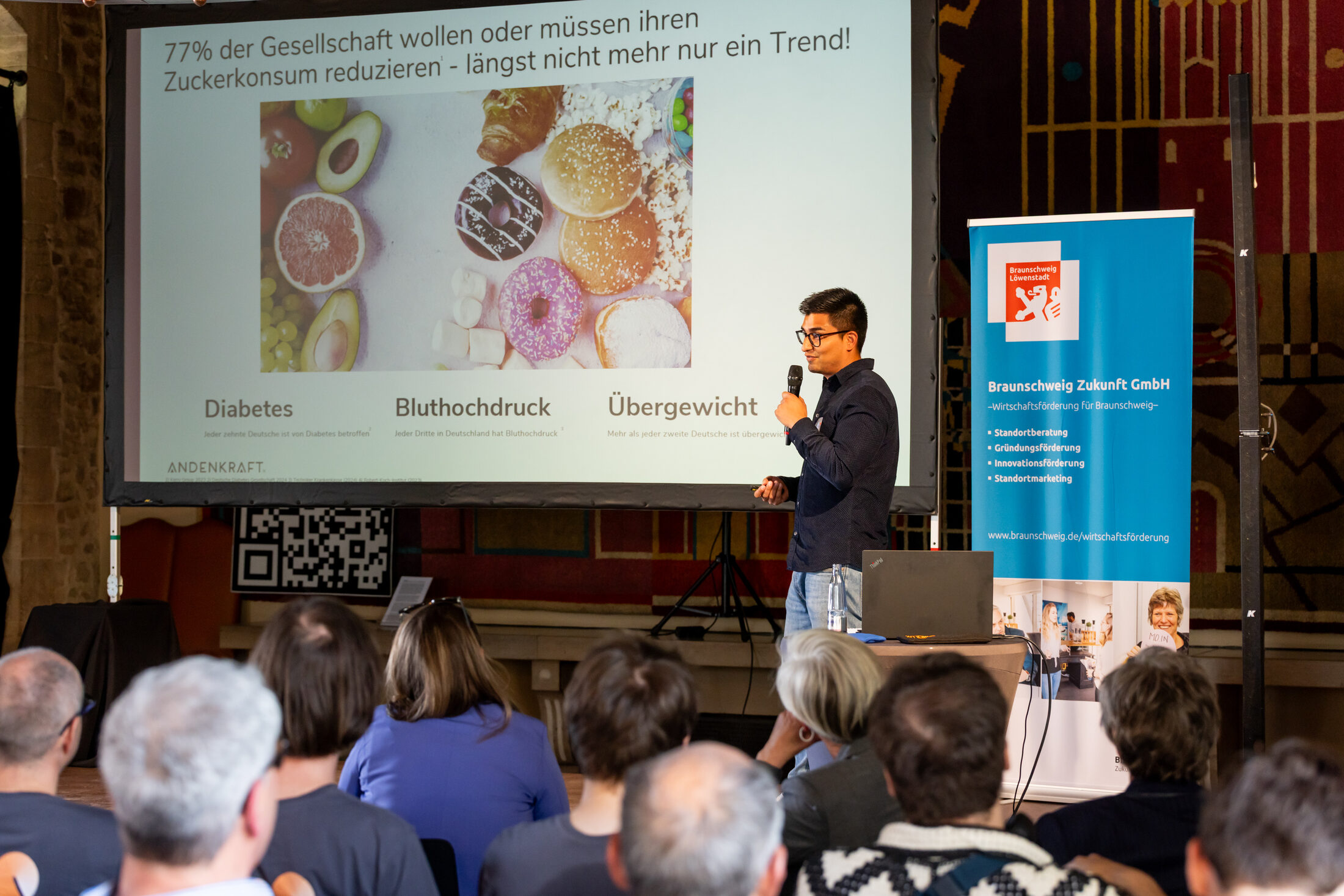Das Bild zeigt einen Mann auf der Bühne (Wird bei Klick vergrößert)