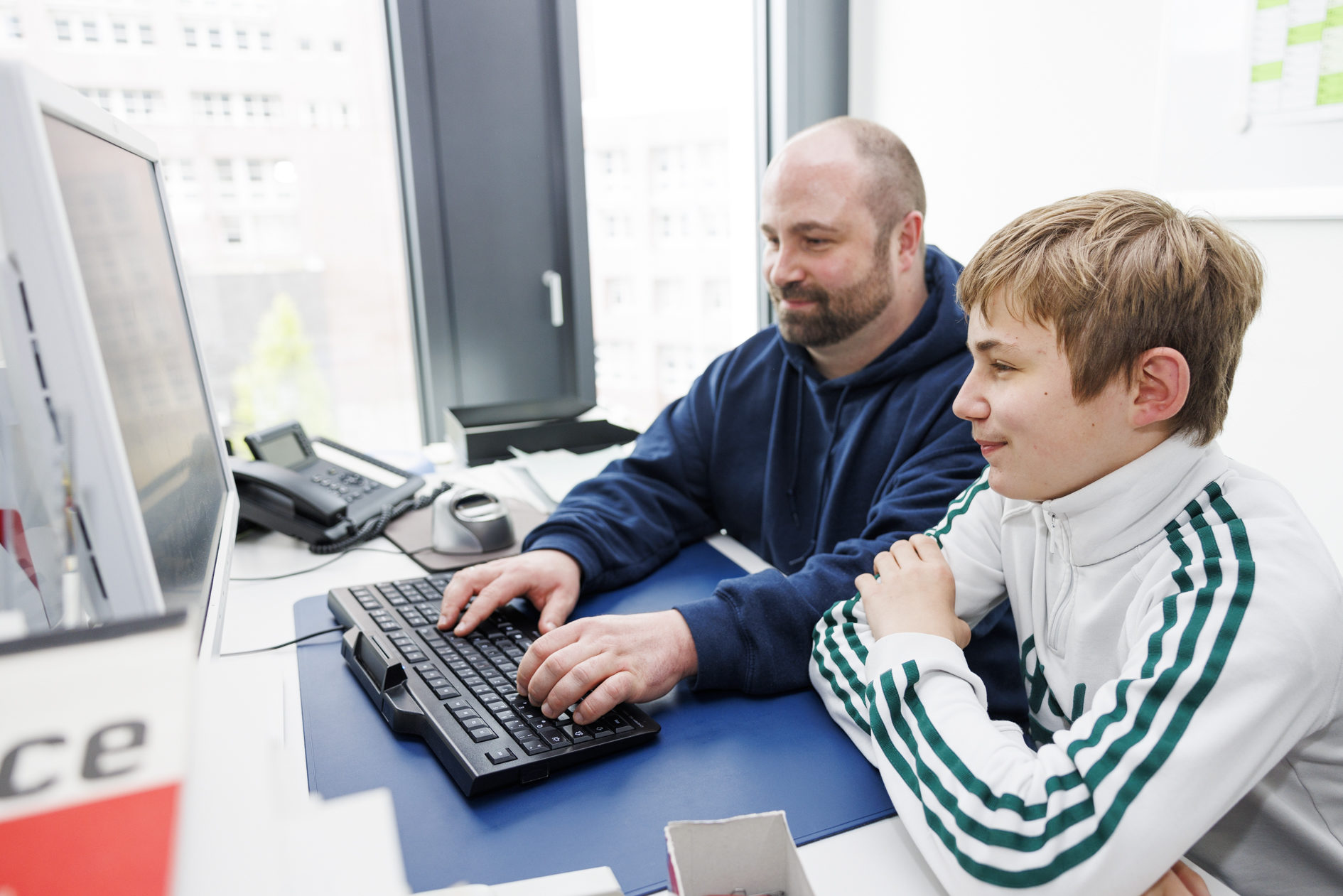 Zukunftstag bei der Stadt Braunschweig. Ein Mann mit einem Jungen am Computer. (Wird bei Klick vergrößert)