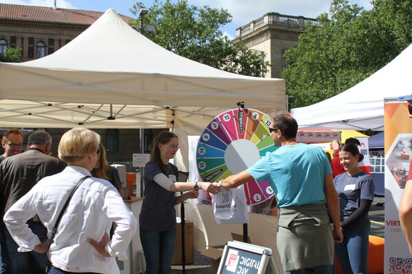 Das Bild zeigt Menschen, die an den Digital Day 2023 besuchen und bei einem Gewinnspiel gewonnen haben.