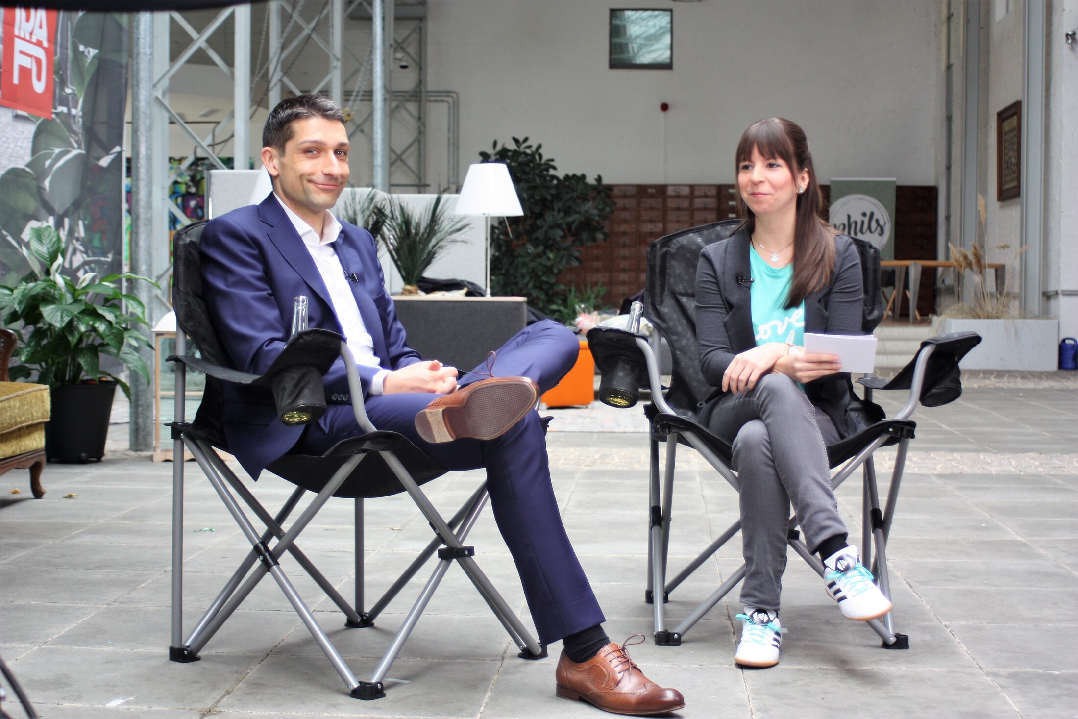 Florian Bernschneider mit Jennifer Haacke beim Dreh im TRAFO Hub in den obligatorischen "Auf eine Limo mit"- Klappstühlen. (Wird bei Klick vergrößert)