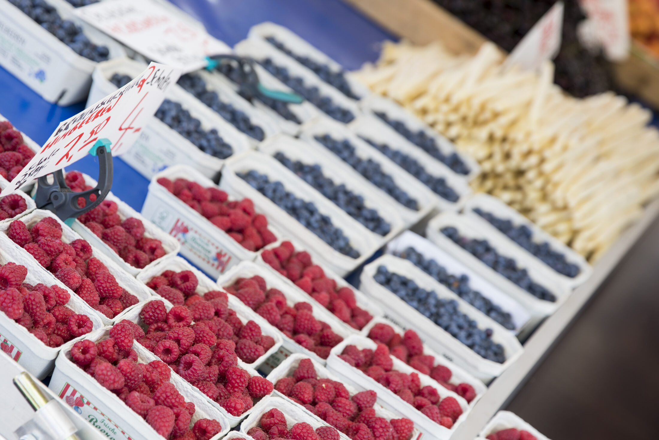 Himbeeren, Blaubeeren und Spargel, die zum Verkauf angeboten werden (Wird bei Klick vergrößert)