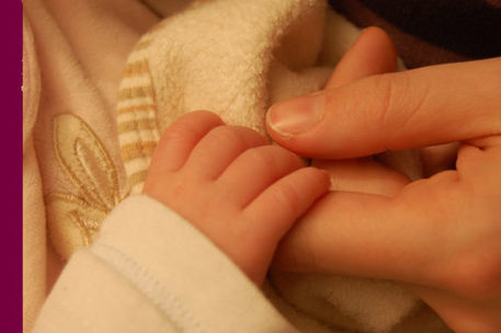 Babyhand umklammert mütterlichen Finger