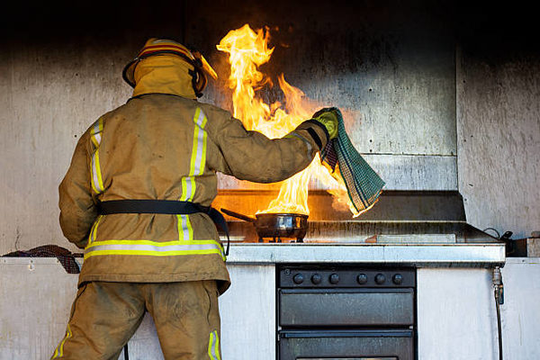 Feuerwehrmann löscht brennenden Topf (Wird bei Klick vergrößert)