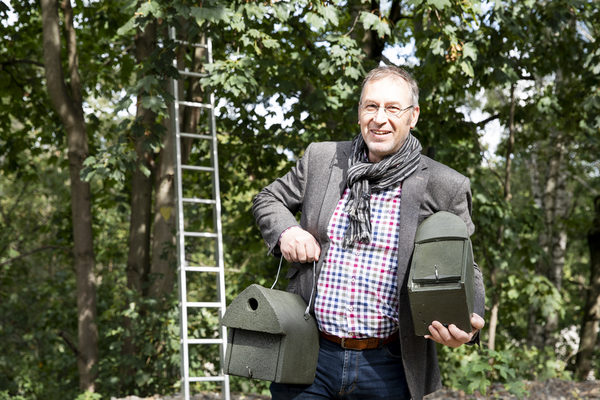 Umweltdezernent Holger Herlitschke hängt Nistkästen auf