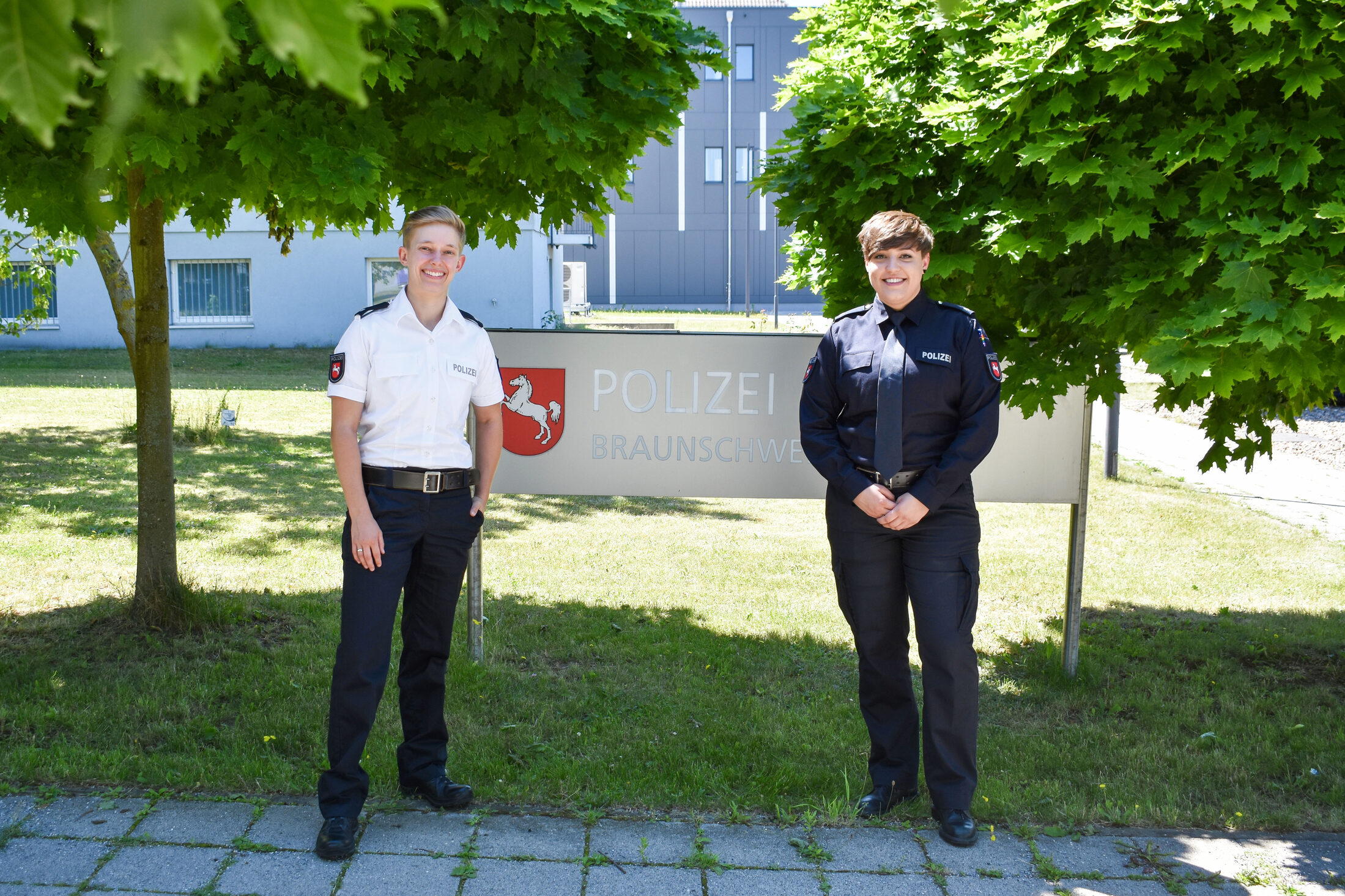 Jules Wurps und Victoria Rückleben vor dem Schild der Polizei Braunschweig