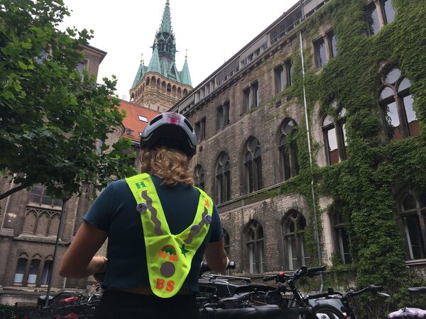 Frau steht mit Fahrrad und schaut auf eine Kirche (Wird bei Klick vergrößert)