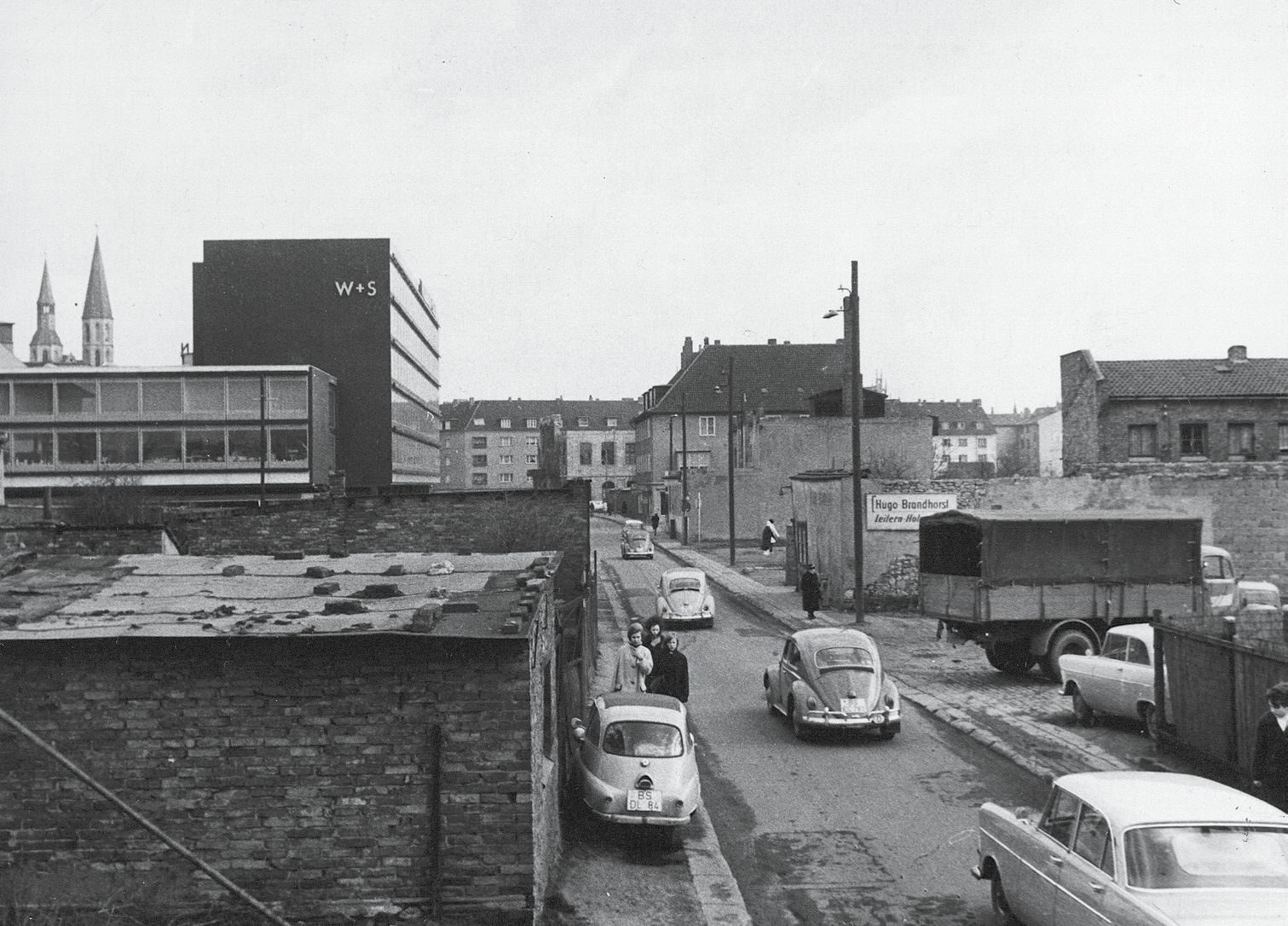 Der Wiederaufbau beginnt, hier an der Langen Straße. Im Hintergrund die Türme der Katharinenkirche, rechts der heutige Welfenhof. (Zoom on click)