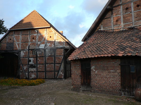 Alte Fachwerkhäuser mit einem gepflasterten Hof.