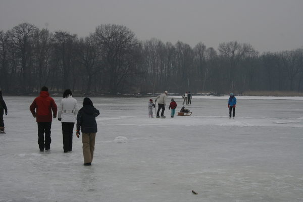 Menschen halten sich auf einem zugefrorenen See auf.