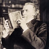 Schwarz-Weiß Fotoaufnahme von Wilhelm Raabe, der ein Buch liest (Wird bei Klick vergrößert)