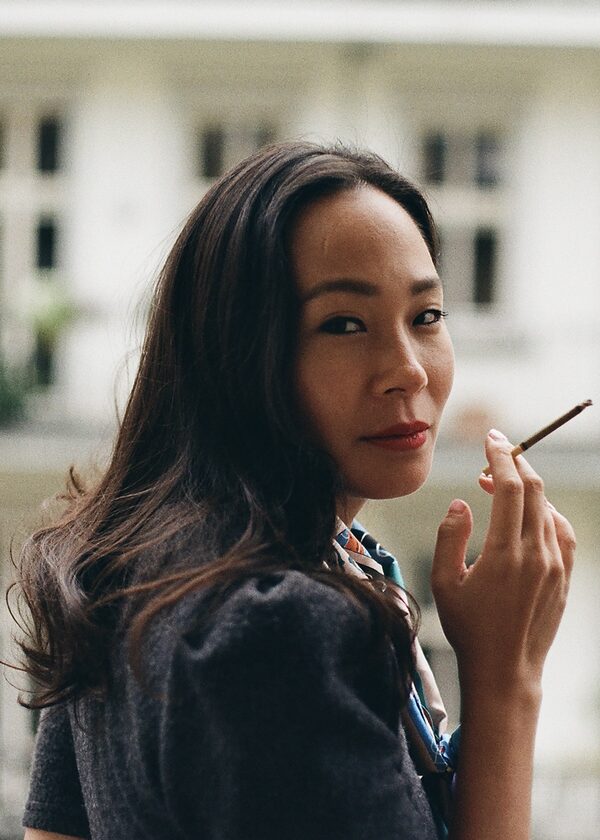 Autorin Ta-Som Helena Yun raucht eine Zigarette und schaut dabei über die Schulter. (Wird bei Klick vergrößert)