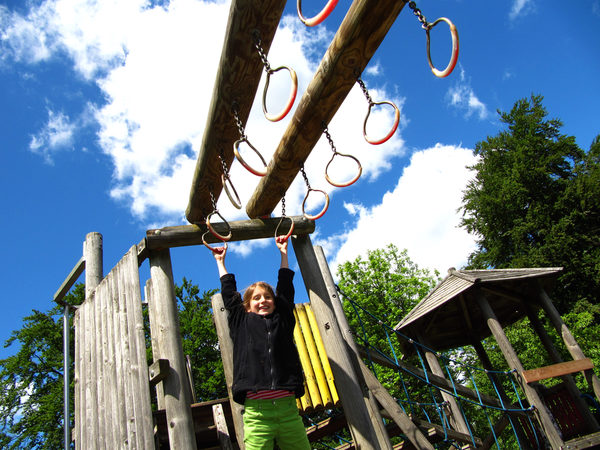 Kind hangelt auf einem Kinderspielplatz (Wird bei Klick vergrößert)