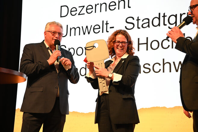 Stefan Lemke, Geschäftsführer Stadthalle Braunschweig Betriebsgesellschaft mbH, übergibt symbolisch den Schlüssel der Stadthalle an Natascha Wessling, Geschäftsführerin der Struktur-Förderung Braunschweig GmbH. (Wird bei Klick vergrößert)
