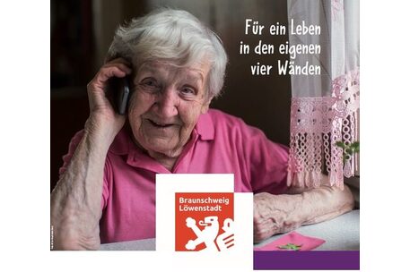 Eine Seniorin telefoniert und lächelt in die Kamera