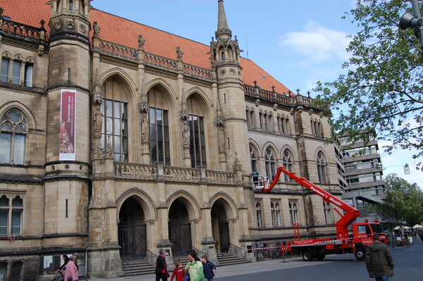 Firma Beyrich befestigt die beiden Kaiserjahr-Banner am Rathaus. (Wird bei Klick vergrößert)