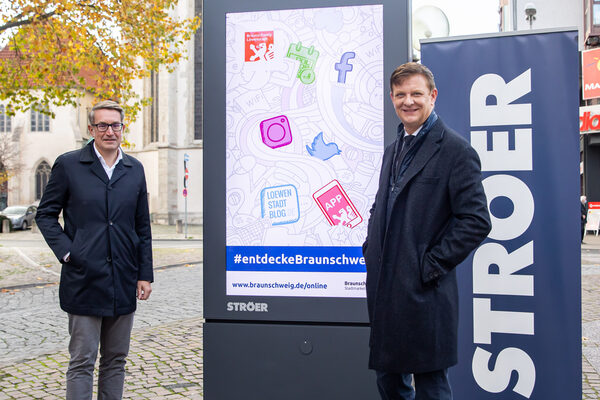 Gerold Leppa, Geschäftsführer des Stadtmarketings, und Harald Rotter, Ströer-Niederlassungsleiter Braunschweig, präsentieren einen der neuen Cityscreens am Standort Ecke Schild/Meinhardshof in Braunschweig. (Wird bei Klick vergrößert)