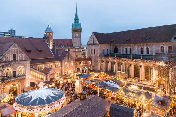 Der Blick von oben auf den stimmungsvoll beleuchteten Weihnachtsmarkt herab. Im Hintergrund ist der Rathausturm zu sehen.