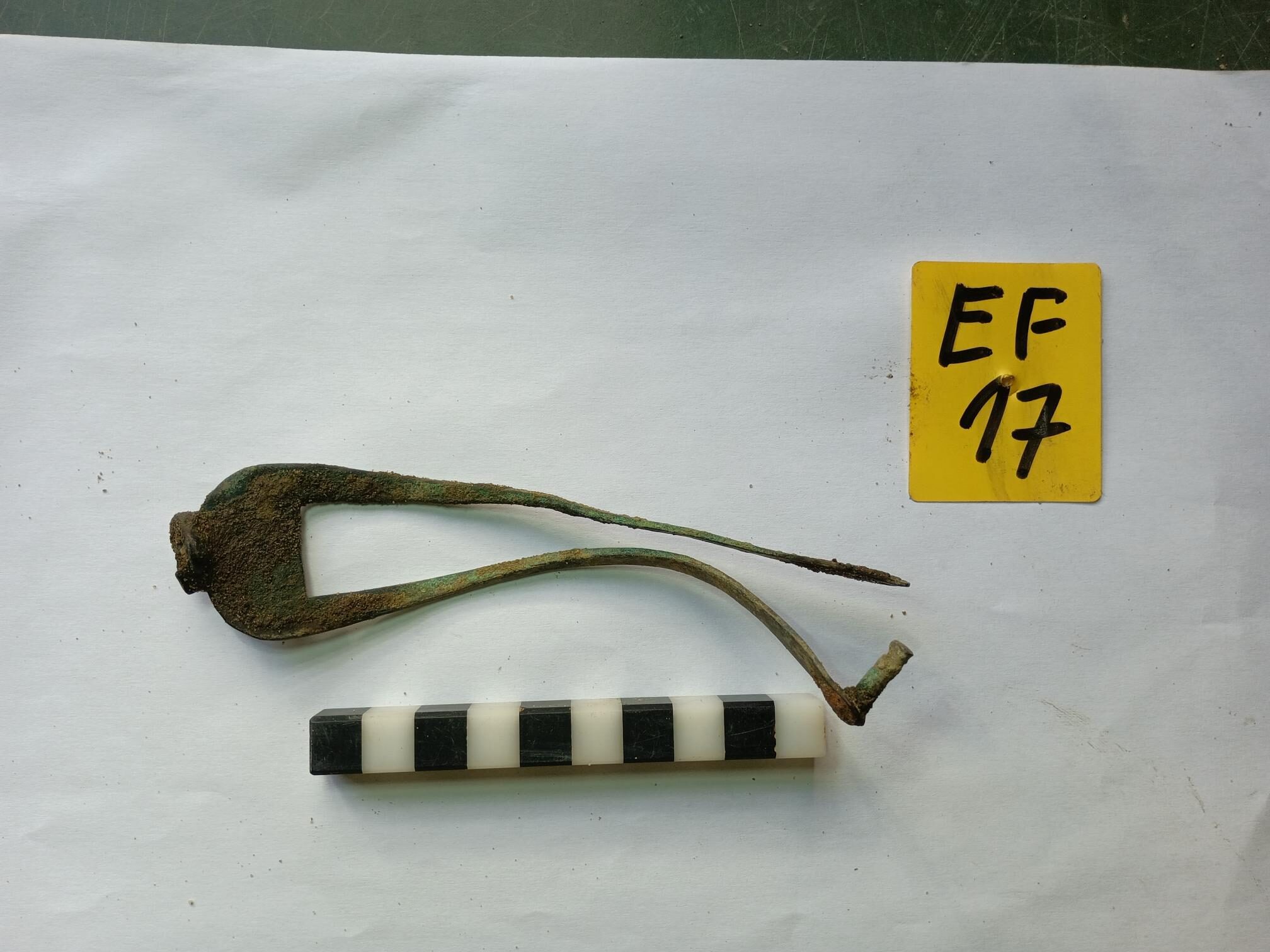Fragment einer Klappwaage. Unter zahlreichen Siedlungsabfällen wurde es in den Pflanzgruben im Westen und Norden des Hagenmarkts gefunden. Hier konnten keine Gebäude nachgewiesen werden, aber der Platzaufbau bis in die Gründungszeit mit seiner Untergrundbefestigung aus Holzknüppeln. (Wird bei Klick vergrößert)