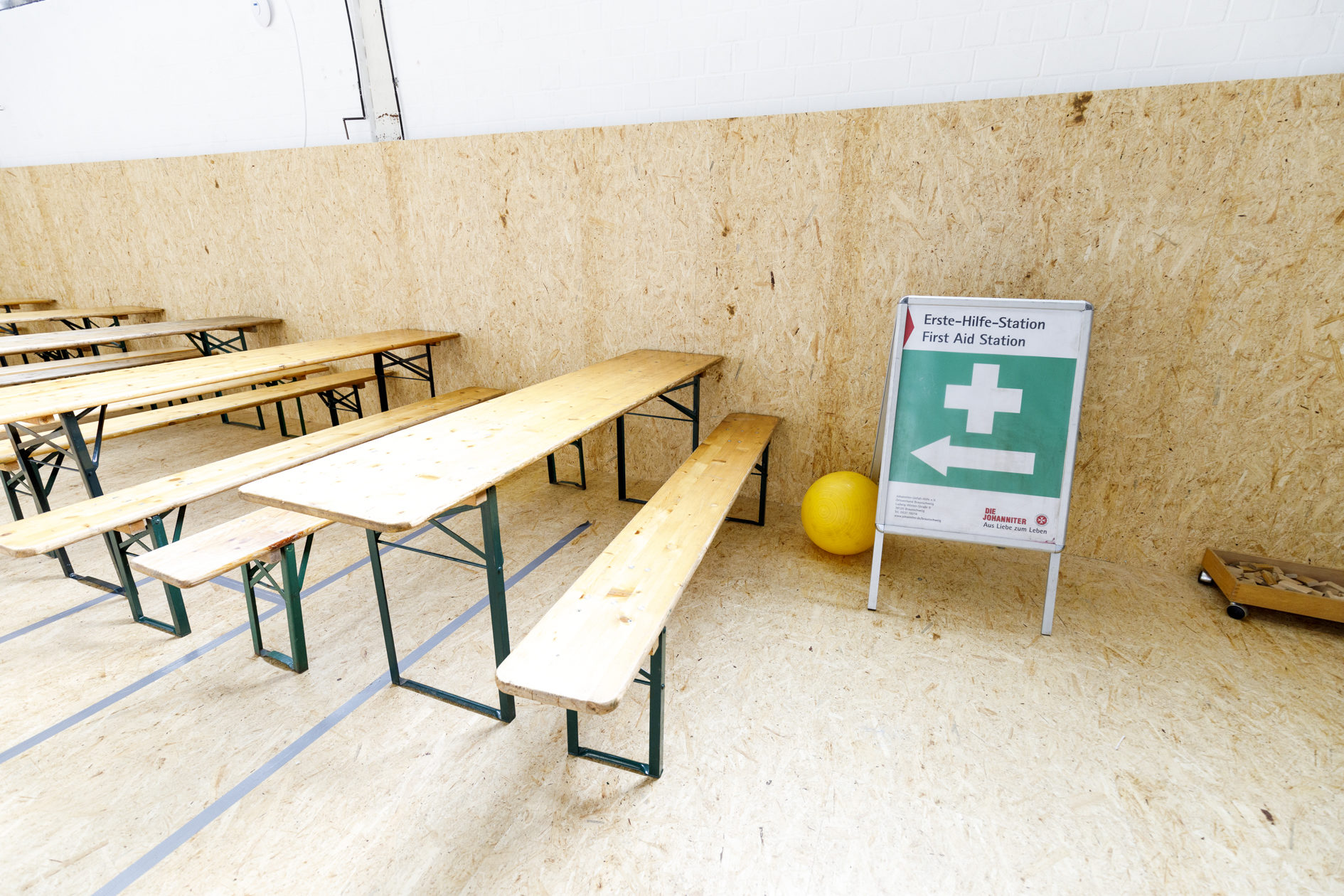 Schild "Erste-Hilfe-Station", daneben Tische und Bänke (Wird bei Klick vergrößert)