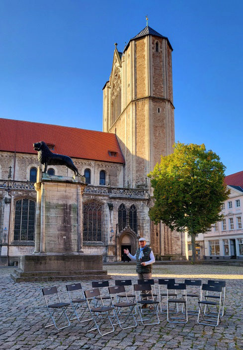 Stadtführer auf dem Burgplatz neben zwei Stuhlhalbkreisen (Wird bei Klick vergrößert)