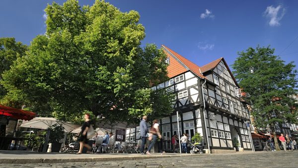 Das Bild zeigt Kopfsteinpflaster vor einem Fachwerkhaus an der Ecke des Magnikirchplatzes. (Wird bei Klick vergrößert)