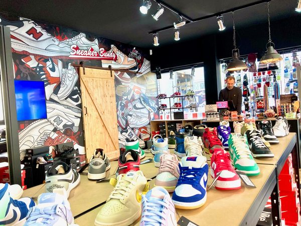 Das Bild zeigt einen Verkaufstisch mit bunten Schuhen in dem Geschäft "Sneaker Bundy". (Wird bei Klick vergrößert)